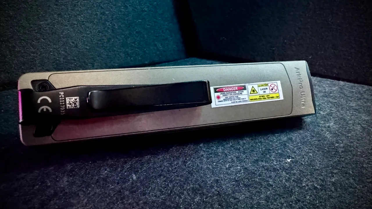 Underside of the Olight ArkPro Ultra showing the deep-carry factory pocket clip riveted to the flat body